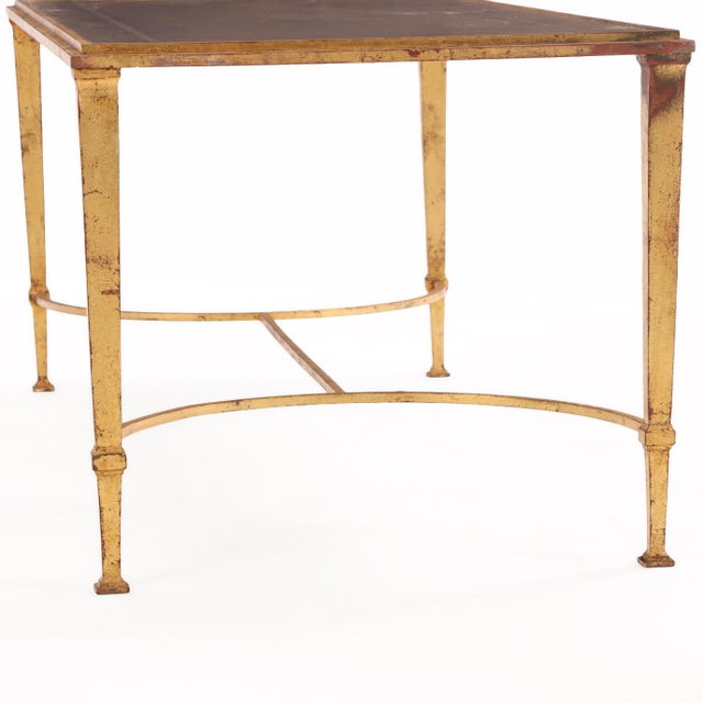 The rectangular glass top features a refined reverse-painted inset surface set within a gilt-iron frame, supported by...