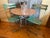 An atmospheric bistro table from the early 1900s in France. The table has three curved iron legs connected by crossbars....