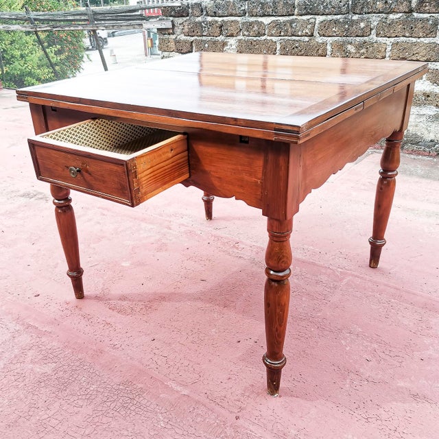 This extendable table is an authentic piece of Italian furniture dating back to the 19th century, combining the rustic...