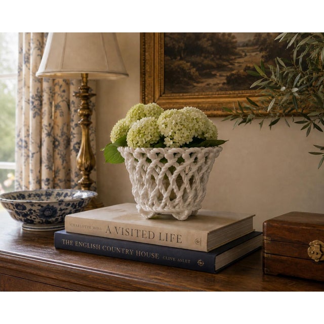 An elegant trompe l'oeil porcelain cachepot crafted in the form of a handwoven rope basket. Executed in glossy white...