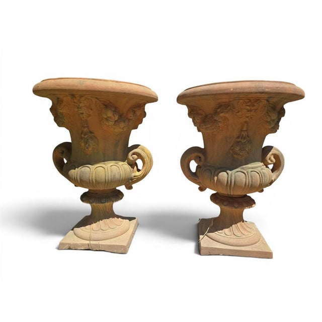 Elegant pair of decorative urns crafted in renowned Impruneta terracotta during the 1960s. Richly adorned with sculpted...