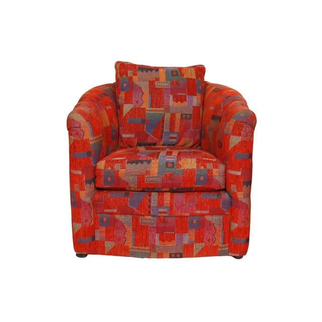 A pair of postmodern barrel chairs upholstered throughout in a bold geographic Memphis jacquard in red with yellow, purple...
