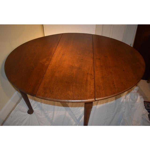 English oval top walnut dining table of the 1700s , in the Queen Anne style. The turned legs terminate in a powerful...