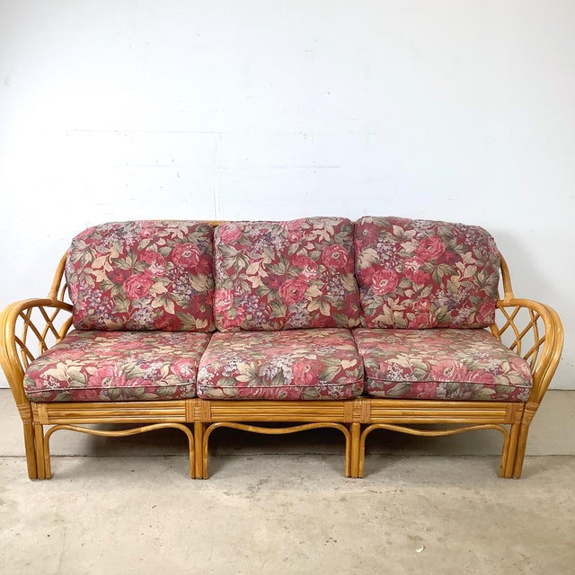 An exceptionally sculptural vintage rattan sofa featuring dramatic architectural latticework, gracefully curved arms, and...
