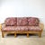 An exceptionally sculptural vintage rattan sofa featuring dramatic architectural latticework, gracefully curved arms, and...