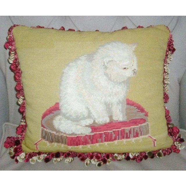 A lovely 19th c. needlepoint pillow with bouillotte fringe and a red silk back. Features a white cat sitting on a pillow...