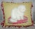 A lovely 19th c. needlepoint pillow with bouillotte fringe and a red silk back. Features a white cat sitting on a pillow...