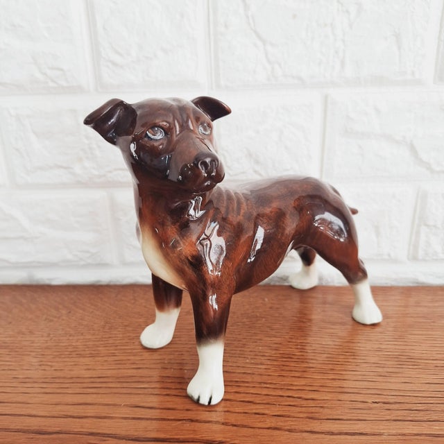 A fabulous glazed porcelain figurine of a Staffordshire Bull Terrier manufactured in England in the 1970s by the...