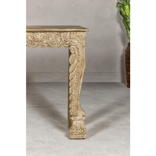 A Mughal style painted console table with carved apron and legs. This Mughal style painted console table captivates with...