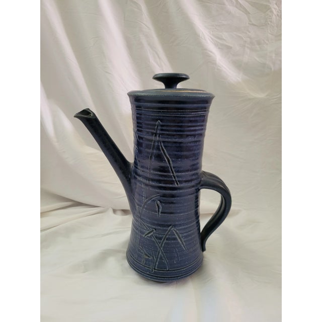 Tall Studio Pottery Pitcher from the 90s. Features a grass-like motif with blue matte glaze. Lidded pitcher is glazed on...