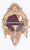 A pair of carved giltwood three-light mirrored girandoles with shell motif tops. Graceful oval mirror backs with a triple-...