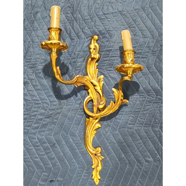 A matched pair of richly modeled late 19th-century French wall sconces crafted in solid brass, each featuring two...