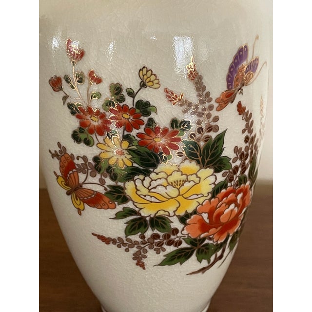 Brightly painted Satsuma vase depicting butterfly garden with flowers in red, yellow, orange and purple. Richly detailed...