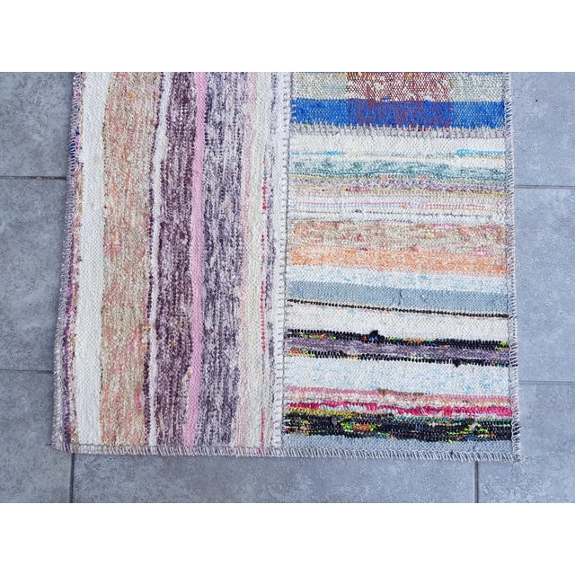 This is a vintage Turkish Oushak rug from the Mid 20th Century. The piece was hand-knotted.