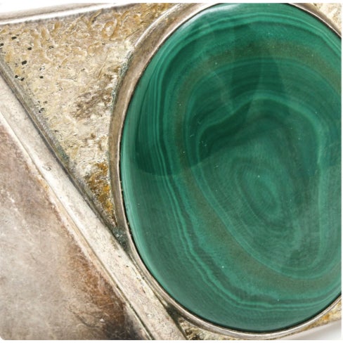 Unique modernist sterling silver malachite cuff. This piece features a malachite cabochon housed in a textured,...