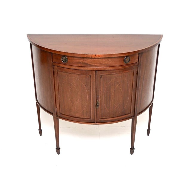 A beautiful antique Edwardian inlaid bow front cabinet. This was made in England, it is in the Sheraton revival style and...