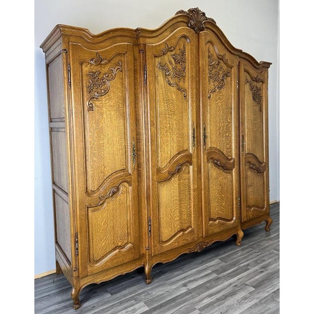 This impressive Vintage French Louis style wardrobe displays rich carved detailing, a sweeping shaped cornice with ornate...