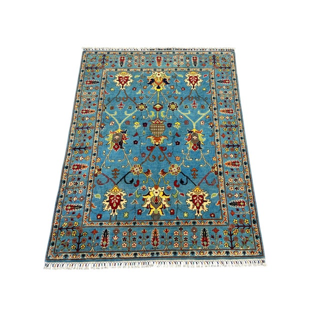 A sky blue field gives this Persian style rug a bright backdrop for its scrolling vines and stylized flowers. Cream,...