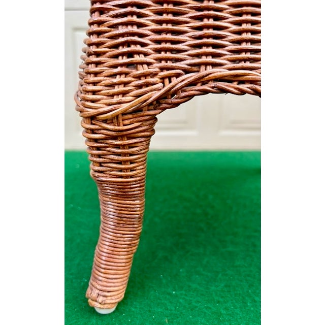 Vintage wicker footstool with a hand-stitched needlepoint top. Sometimes classified as "Granny Chic" or coastal cottage...