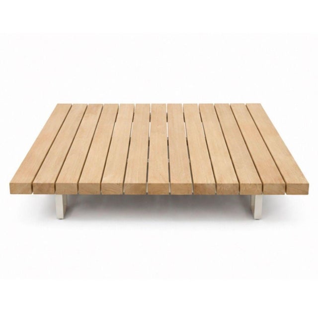 This Paola Lenti table features a modern, low-profile design with a slatted wood top and sturdy metal legs. Its clean...