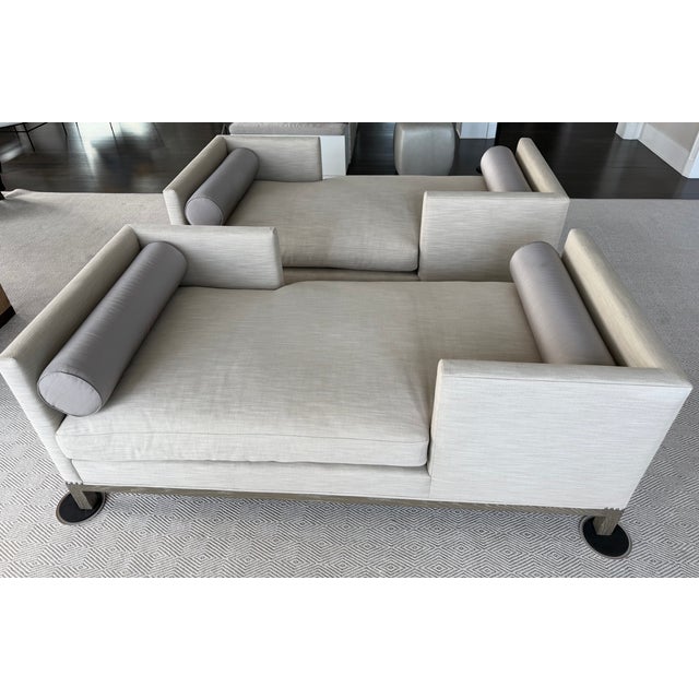 Beautiful matched pair of custom A. Rudin No. 2725 tête-à-tête sofas upholstered in a refined neutral palette. The double-...