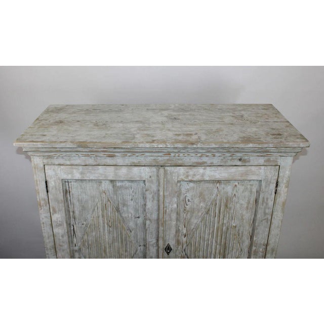 A beautifully timeworn Swedish pine cabinet dating to the late 18th to early 19th century, offering a refined yet...