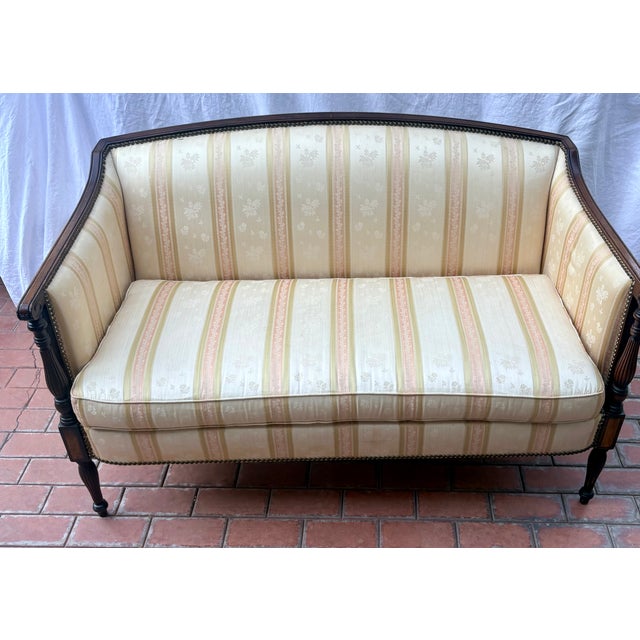 Description: Elevate your space with this stunning late 20th Century Federal style mahogany settee, meticulously crafted...
