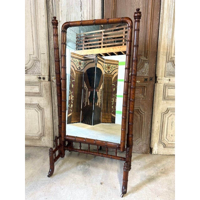 A beechwood cheval mirror in the faux-bamboo style, circa 1900. The lower section features openwork woodwork, and the...