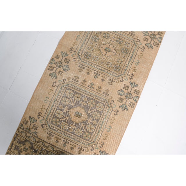 This is a vintage Turkish Oushak rug from the Mid 20th Century. The piece was hand-knotted.