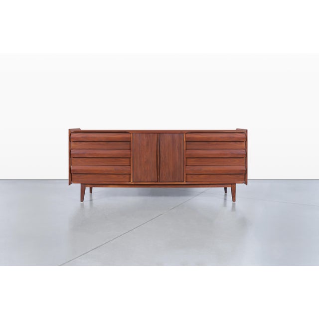 Allow me to present a stunning mid-century modern walnut dresser, a remarkable piece crafted by Lane Furniture in...