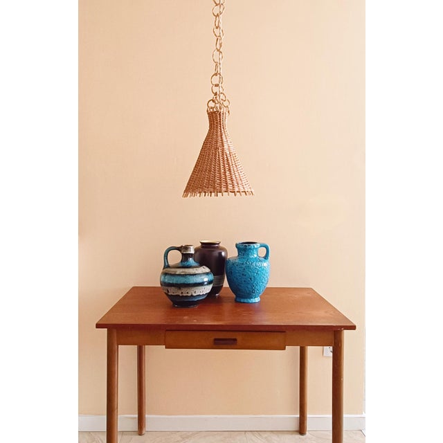 Super stylish vintage Mid-Century Modern conic shaped wicker pendant lamp, handmade in Spain circa the 1950s. The hanging...