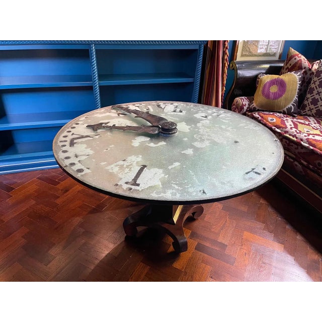 A huge antique French glass-front tower clock face with large painted Roman numerals on a white background with prominent...