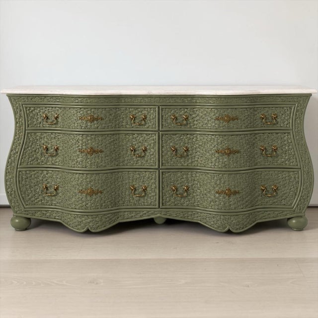 This is a wicker serpentine chest by WhiteCraft for Woodard. It has a travertine top that is not affixed to the piece....