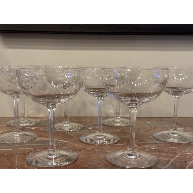 This is a set of 8 vintage blown glass champagne coupes. They have a wide, shallow bowl and a long slender stem. They have...