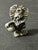 Vintage 1970s hand cast lion figurine. The lion is depicted in a cartoonish style holding a football. Approximately 1” x 1”.