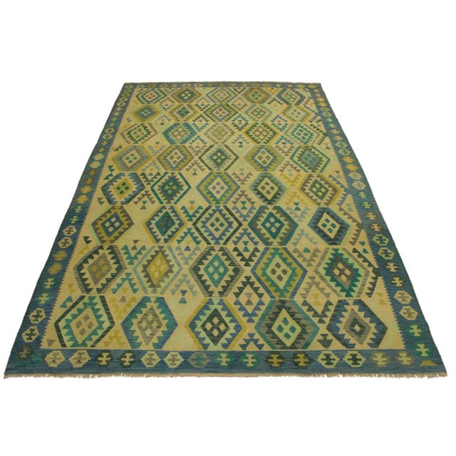 Add a touch of elegance to your home with this casual chic hand woven Tribal Kilim wool rug. Constructed on a loom by...