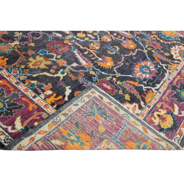 Beautiful modern Oushak hand-knotted wool rug with a grey field. This piece has a purple-designed frame and multicolor...