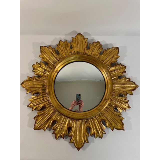 A gorgeous 19" diameter French style giltwood Sunburst Wall Mirror, circa Mid 20th Century. This stunning hand crafted...