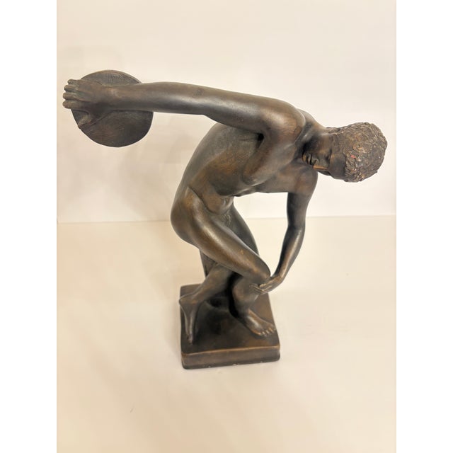 A nude athlete in a contorted pose on a pedestal preparing to throw a discus. Myron's skill to depict the movemnt of the...
