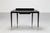 Elegant console in black lacquered wood, glass top and long brass tips, made in Italy in the early 1950s in the style of...