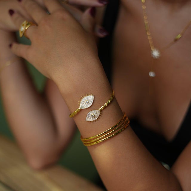 The Diamond & Gold Guardian Evil Eye Cuff Bracelet is a stunning 24k gold-plated brass twisted cuff bracelet, featuring...
