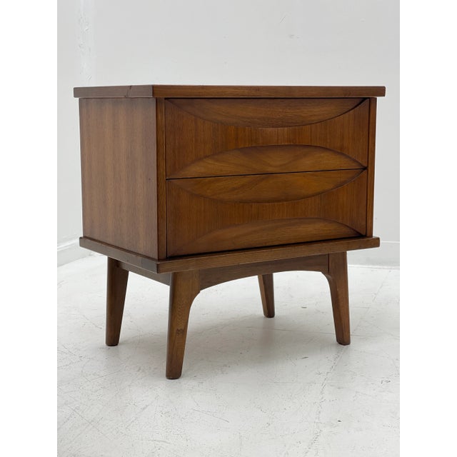 Unique Mid-Century Night Stand with walnut construction, including sculpted drawer fronts, tapered legs and plenty of...
