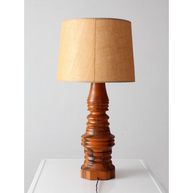 A sculptural vintage table lamp from the 1960s–70s, turned from alternating bands of warm honey-toned and darker wood. The...