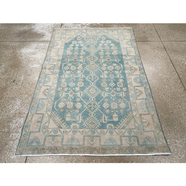 This mid-20th-century Persian Malayer throw rug presents a balanced geometric-floral composition across a muted blue...