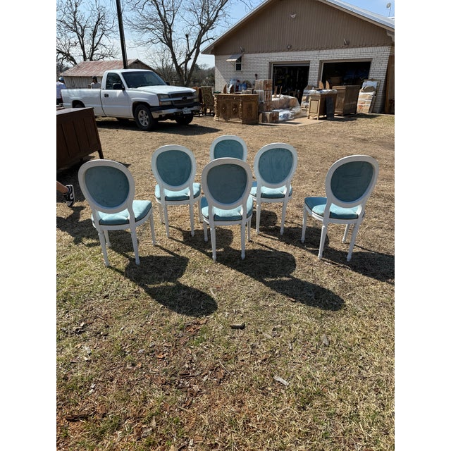 A set of six 19th century Louis XVI-style dining chairs featuring classic oval "medallion" backs, fluted tapered legs, and...