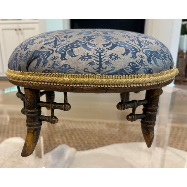 Antique petite oval shaped footstool in the Chinoiserie style upholstered in Fortuny Richelieu Fabric retaining the...
