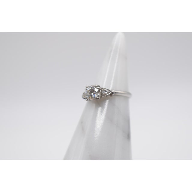 This is a stunning diamond ring from the 1930s. It is platinum with an old mine-cut center diamond. It is approximately...