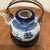 This antique Chinese blue and white porcelain teapot features wire handles and a surguch stamp on the lid, adding to its...