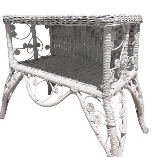 Vintage Palm Beach Regency wicker side table / magazine rack featuring an exceptional sculptural silhouette with intricate...