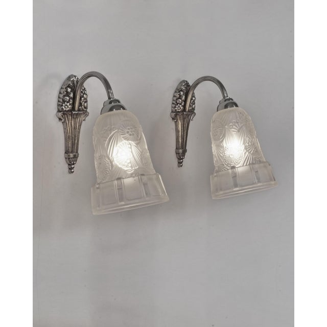 Hettier et Vincent A pair of 1925s French art deco wall sconces in nickel plated bronze and clear frosted moulded-pressed...
